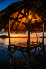 Sunset over wooden beach bar in sea and hut on pier in koh Mak island, Trat, Thailand