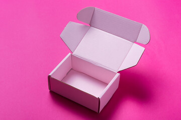 Simple pink cardboard box on color background, top view