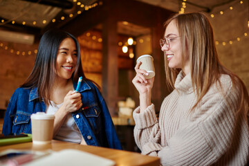 Happy women talking in light cafeteria