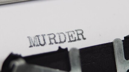 An old fashioned vintage typewriter spelling out the word Murder, horror or thriller story book novel concept
