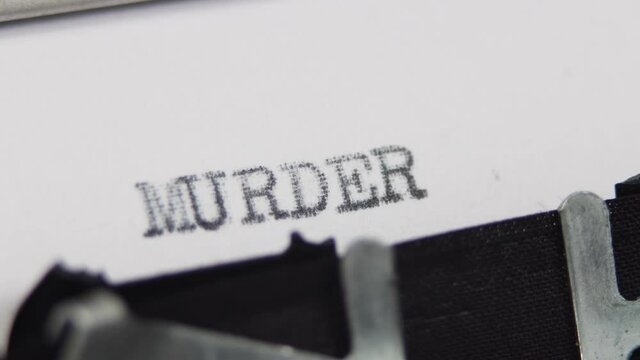 An old fashioned vintage typewriter spelling out the word Murder, horror or thriller story book novel concept