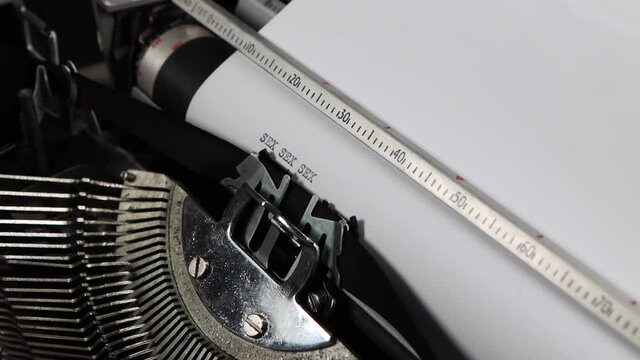 An old fashioned vintage typewriter spelling out the word sex multiple times, old fashioned love letter or romance story novel concept