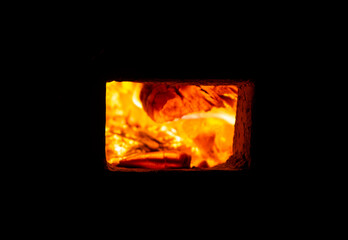 Fire burns in a rectangular oven door