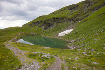 Fototapeta premium Amazing hiking day in one of the most beautiful area in Switzerland called Pizol in the canton of Saint Gallen. What a wonderful landscape in Switzerland at a sunny day. Beautiful alpine lake.