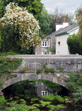 view of the bridge crossing the river with surrounding village houses in cartmel, cumbria