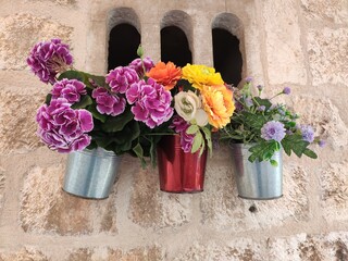 Magnifiques décorations ou meubles de repos posés dans la ville ancienne de Dubrovick, en Croatie, des pots de fleurs accrochés sur le mur historique, de toutes les couleurs, fleurs artificiels