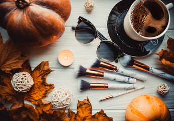 Cup of coffee with pumpkins on wooden white background with a makeup brushes in autumn. Flatlay