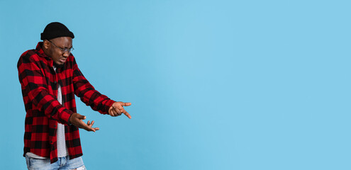 Flyer with young stylish african man wearing casual clothes isolated on navy studio background. Emotions, facial expression concept.