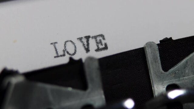An old fashioned vintage typewriter spelling out the word Love, old fashioned love letter or romance story concept