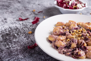 Vegan potato gnocchi with walnut and radicchio sauce.