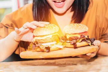 Concept of a large-scale woman : Hungry woman eats a large amount of marinated beef hamburgers....
