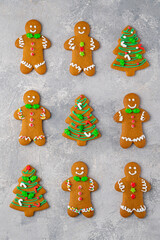 Christmas or New Year food background. Gingerbread cookies decorated with sugar glaze on a gray concrete background. Copy space, top view.