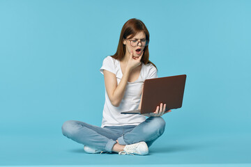 woman with laptop sitting on the floor learning student technology