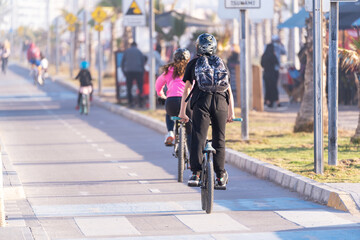 Fototapeta na wymiar young people riding a bicycle on a bikeway in La Serena