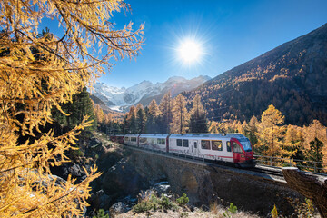 Tourist train on the swiss alps passes through mountains