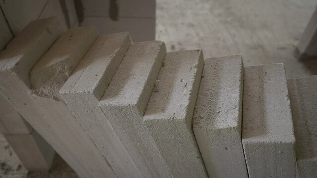 Construction of a multi-storey building from blocks. Concrete blocks are lined up at the construction site.