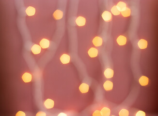 yellow defocused lights garland on pink background