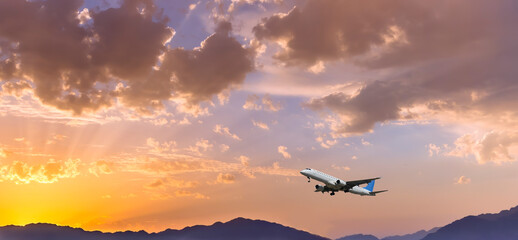 Fototapeta na wymiar Airplane take off above mountain in the sky at dawn