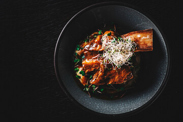 beef rib with mashed potatoes on plate on rustic wooden table dark background