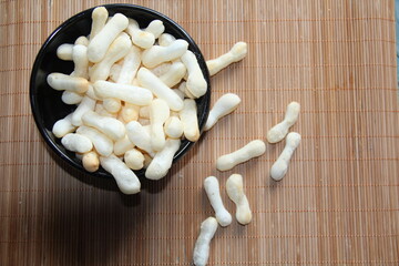 The polvilho biscuit in a black crockery bowl on a bamboo mat.