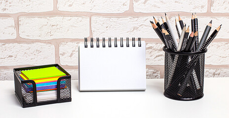 A workplace in the house with bright stickers, pencils in a stand and a clean notebook with a place...