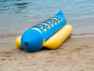 Banana boat rides parked on the sandy beach. Toys for a beach vacation.