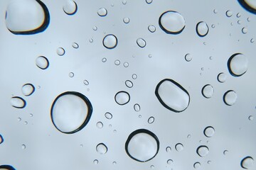 Closeup of Clear Raindrops on Windshield under Cloudy Gray Sky