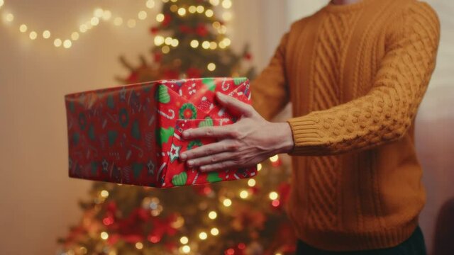 Regalo pacco di Natale con albero nella stanza