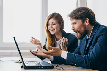 business man and woman sitting at a desk with a laptop communication professionals