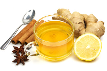 Glass of tea with ginger, lemon, cinnamon sticks and star anise isolated on white background.