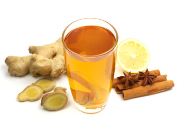 Glass of tea with ginger, lemon, cinnamon sticks and star anise isolated on white background.