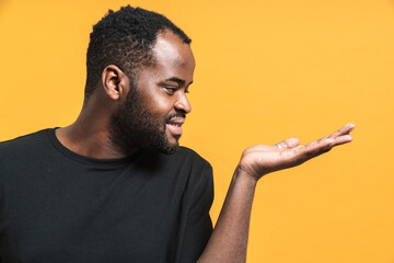 Black bearded man looking aside while holding copyspace