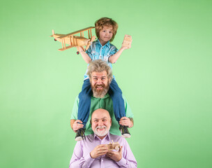 Boy son with father and grandfather with a toy airplane plays on isolated background. Family...