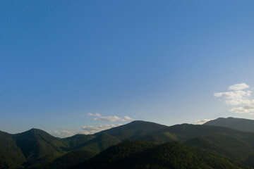 Aerial view of beautiful mountain landscape with forest on sunny day. Drone photography