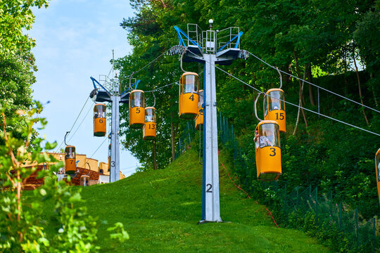 Aerial lift for tourists, yellow cable cars, transport from mountain to sea beach
