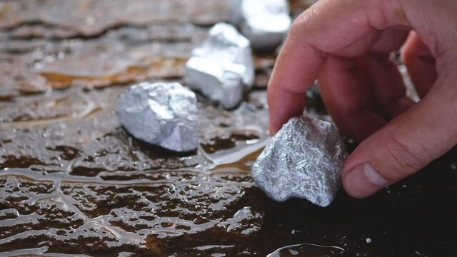 Miners hold in their hands platinum or silver or rare earth minerals found in the mine for inspection and consideration	