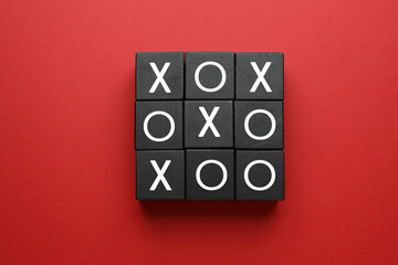 Tic tac toe cube set on red background, flat lay