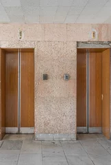 No drill roller blinds Old door Closed old Soviet wooden elevator doors in the old interior in the style of modernism, with walls lined with travertine.