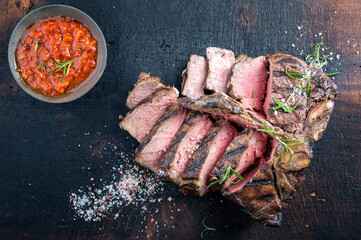 Traditional dry aged barbecue angus porterhouse beef steak sliced with spice and ajvar served as...