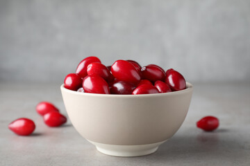Fresh ripe dogwood berries in bowl on light grey table