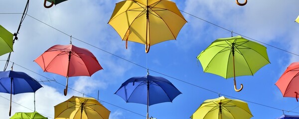 Colorful umbrella in autumn. Hanging umbrellas of different colors on  background of blue sky