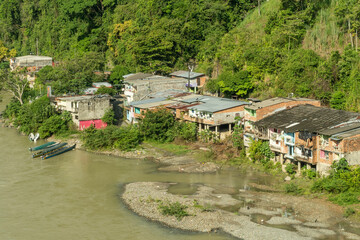 Fototapeta na wymiar Houses and boats on the banks of the Cauca River. Puerto Valdivia, Antioquia, Colombia.