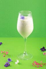 milk shake white cocktail in glass with berries and flowers