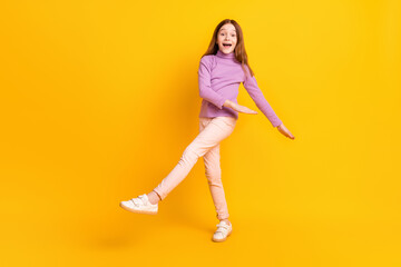 Fototapeta na wymiar Full size photo of happy excited good mood little girl dancing enjoying free time isolated on yellow color background