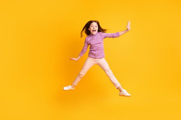 Fototapeta na wymiar Full length body size view of attractive carefree cheerful girl jumping having fun fooling isolated over bright yellow color background