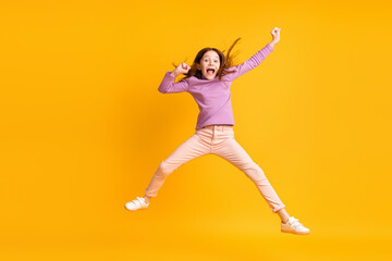 Fototapeta na wymiar Full size photo of happy cheerful excited crazy beautiful little girl jumping screaming isolated on yellow color background