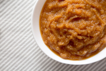 Homemade Raw Apple Sauce in a White Bowl, top view. Flat lay, overhead, from above.
