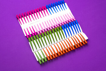 on a purple background hair clips of different colors in sets on a cardboard frame