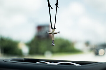 Cross necklace hanging from jeep rearview mirror