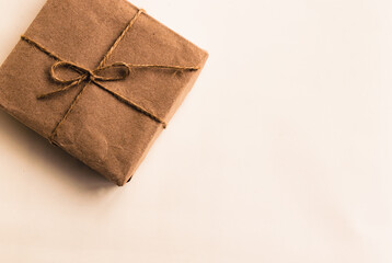 Zero waste Christmas flat lay. Home made. Eco friendly. Copy space. Simple Christmas gift in craft paper on white background. Plastic free. Recyclable package.